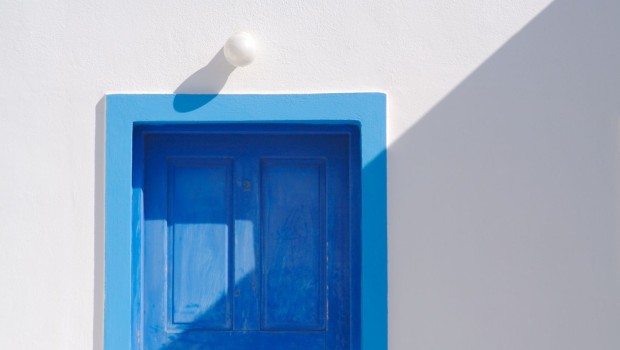 Abstract close-up of Santorini home wall, door and lamp.
